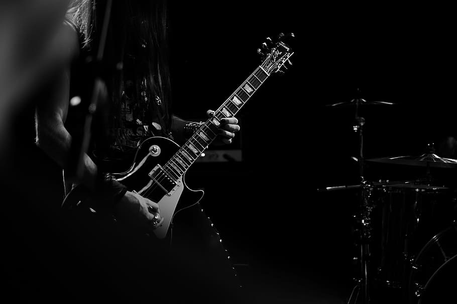 man playing electric guitar, grayscale photography of person holding stratocaster guitar