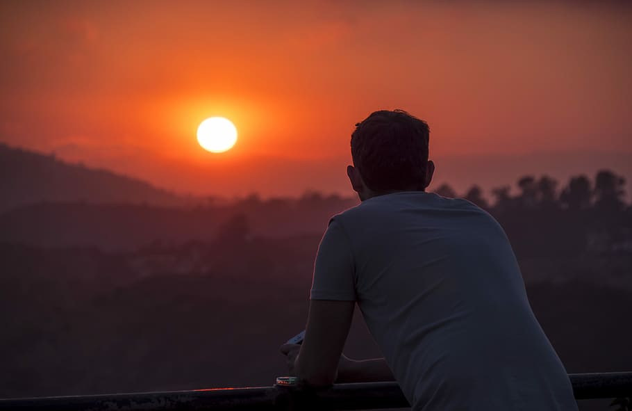 man wearing blue shirt looking at sunset, person looking on sunset on balcony HD wallpaper