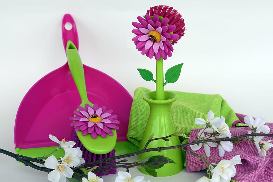 purple plastic dust pan near green and pink flower figurine, clean