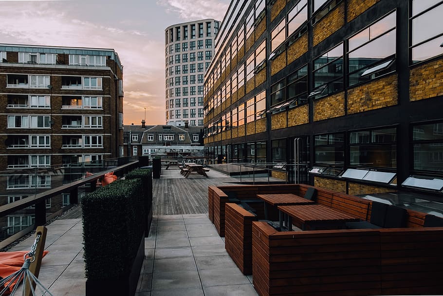architectural photo of buildings during daytime, brown living room furniture set near concrete building at golden hour HD wallpaper