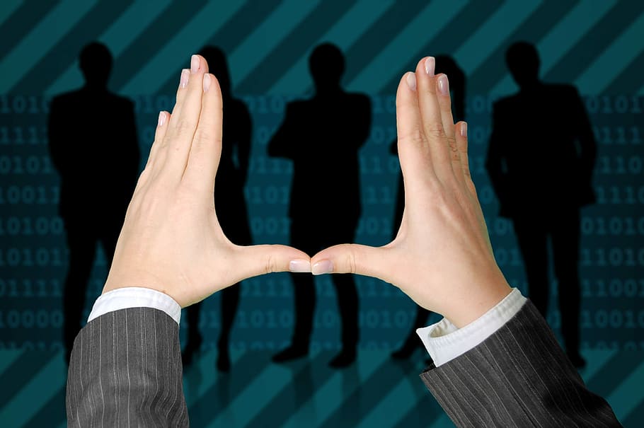 person's hand with silhouette of people in background, business HD wallpaper