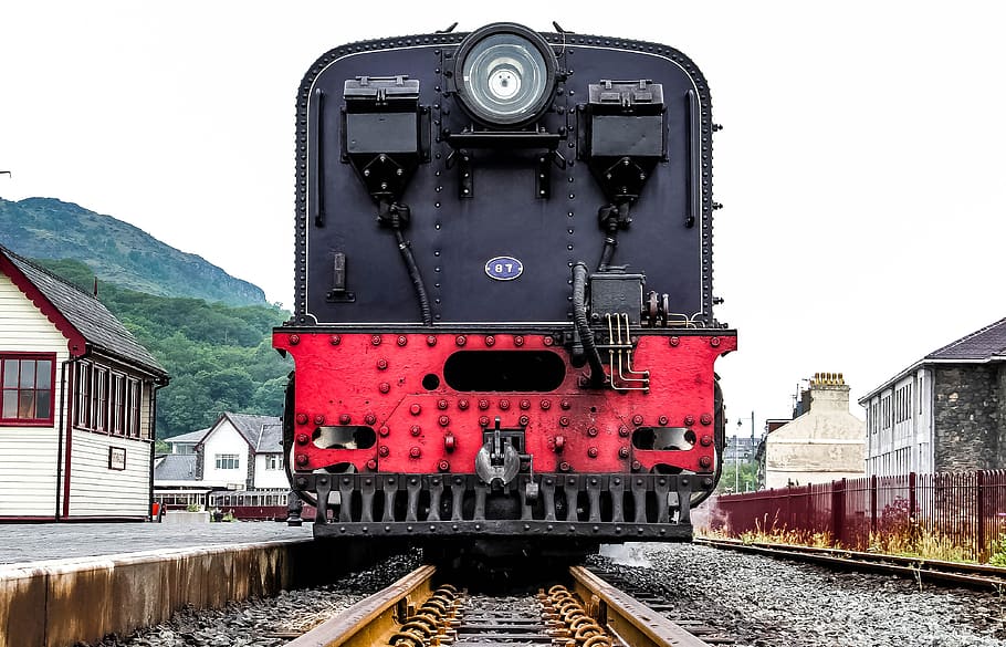 black and red steam train on track during daytime, black and red train