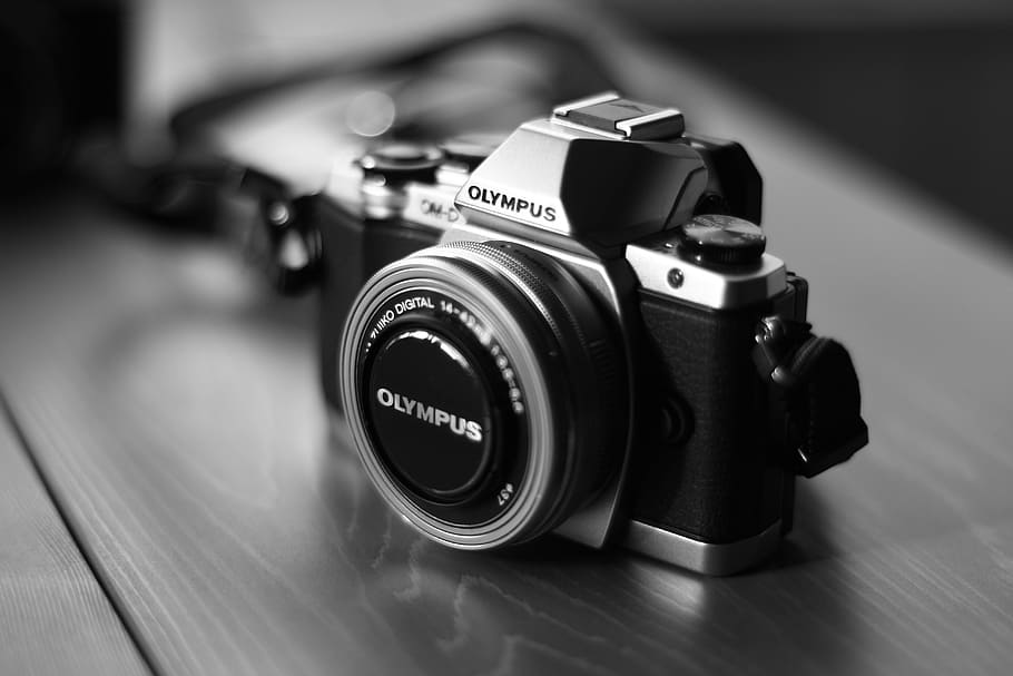 black and gray Olympus MILC camera on brown surface, digital camera HD wallpaper