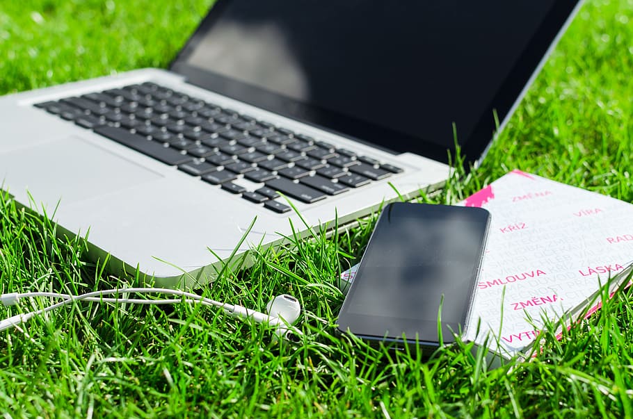 blck and white HP laptop beside black android smartphone on green grass, HD wallpaper