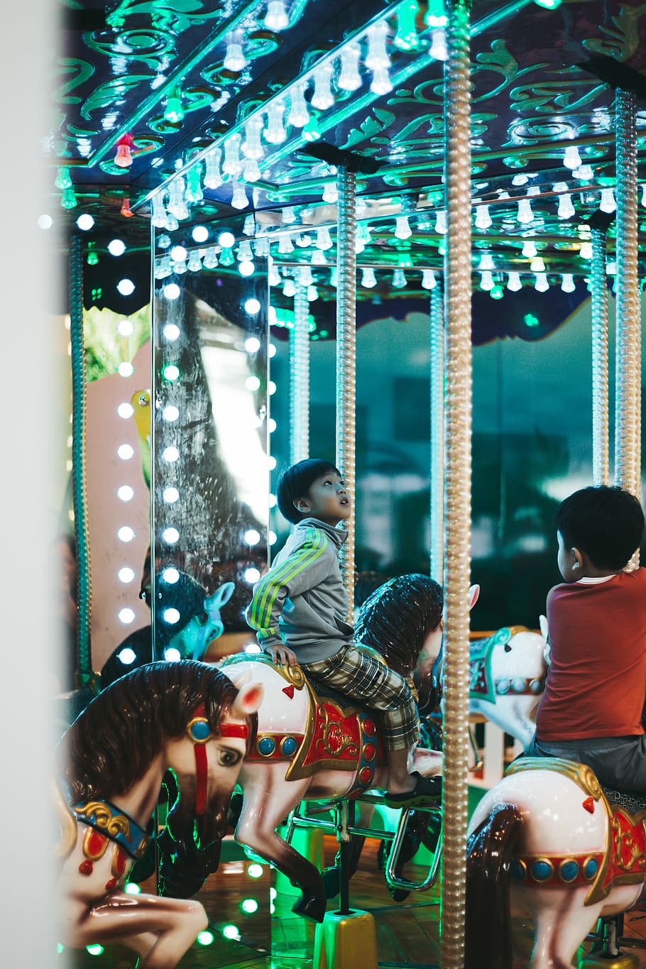 boy riding on carousel, boy riding carousel starring at ceiling with LED lights
