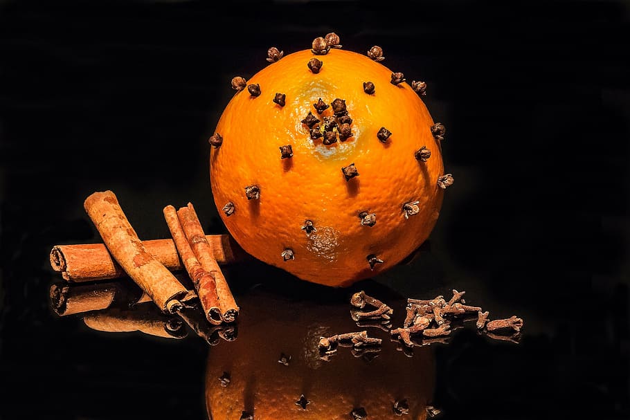 orange fruit studded with earrings, cloves, cinnamon stick, advent decoration