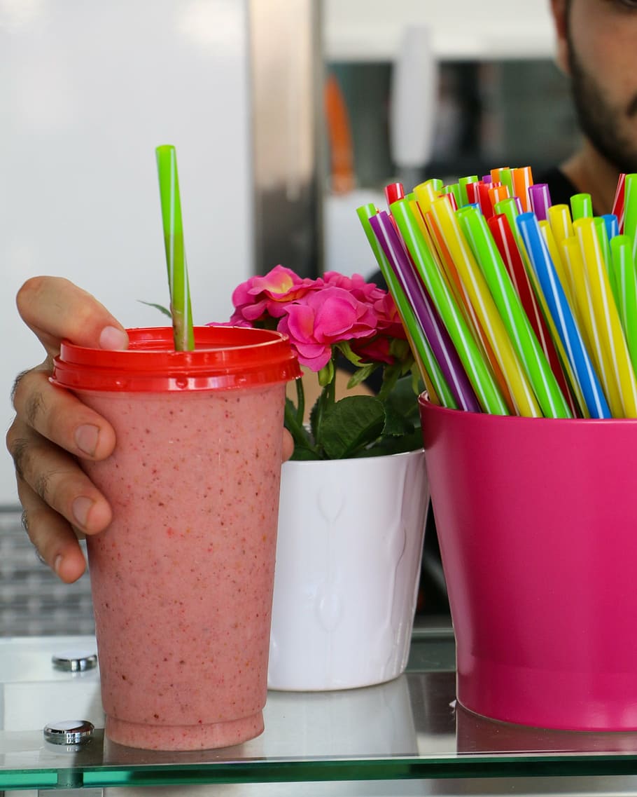 person holding red disposable cup with green straw, smoothie HD wallpaper