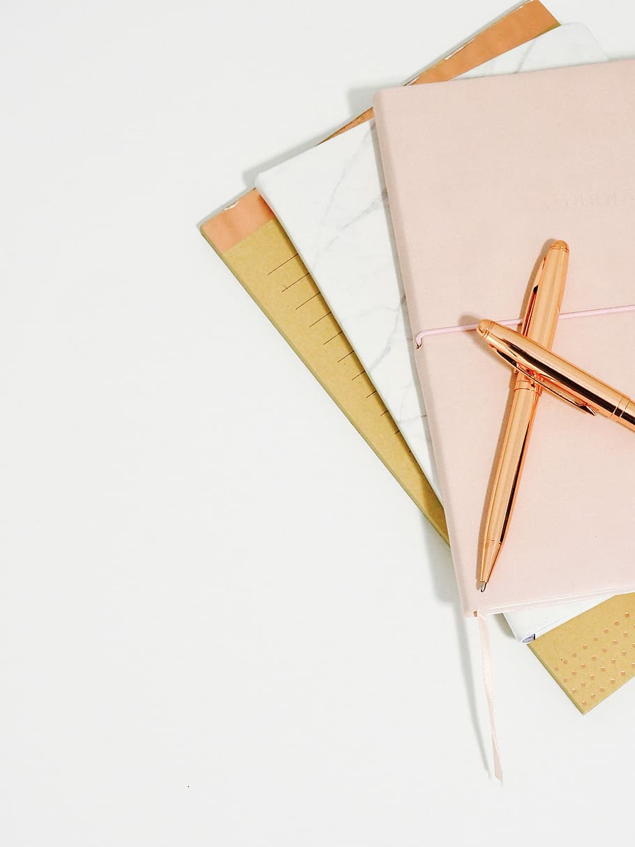 ballpoint pens on pink notebook, two gold retractable pens, copper HD wallpaper