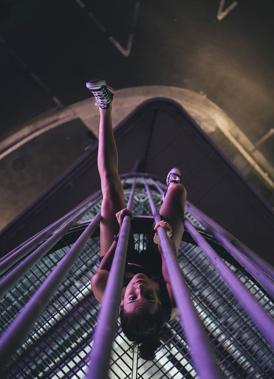 woman on purple metal tower during nighttime, woman sitting on grille HD wallpaper