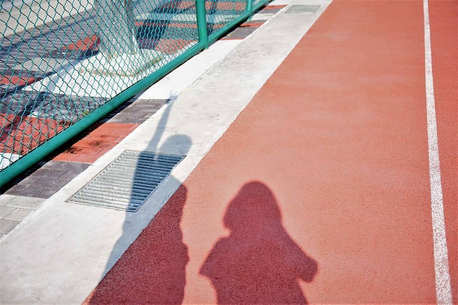 two person's shadow on brown and red surface, two person silhouettes near green metal fence HD wallpaper