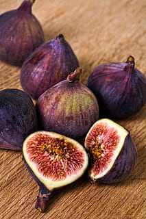 shallow focus photo of purple figs on brown wooden surface HD wallpaper