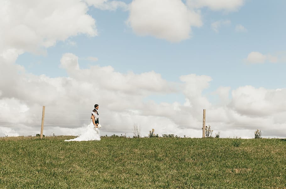 couple walking on green grass, newlywed couple walking on field under white and blue sky HD wallpaper
