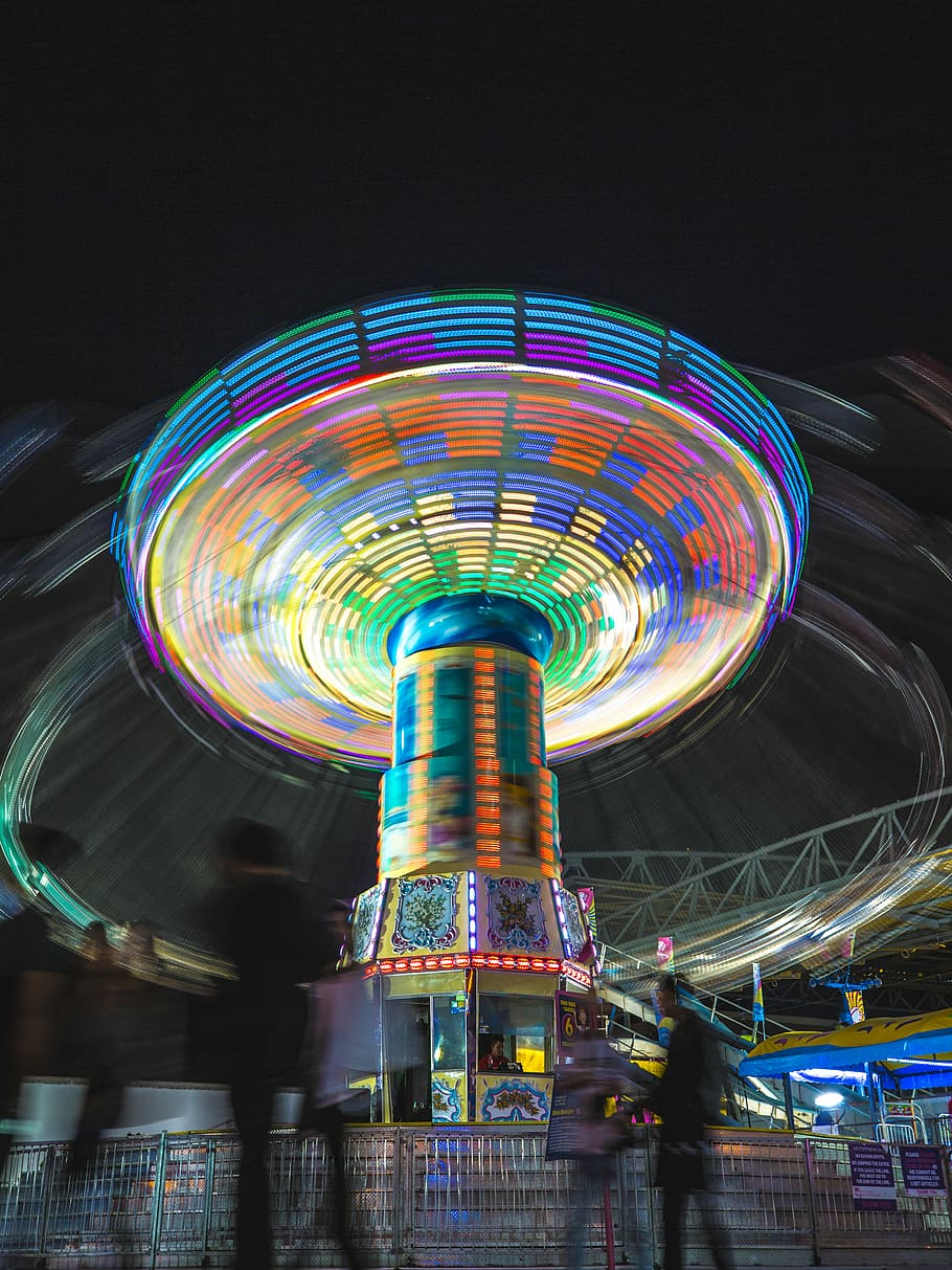 time-lapse photography amusement park ride at night, people walking near multicolored amusement park ride at daytime HD wallpaper