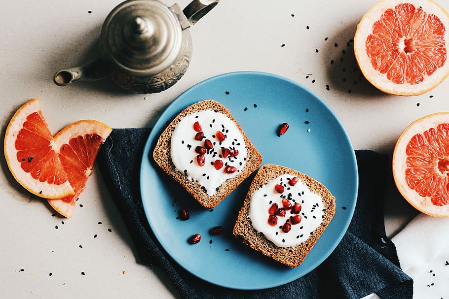 two baked breads with white mayonnaise and red fruits on top in round blue ceramic plate, bread loaf slices served on blue ceramic plate HD wallpaper