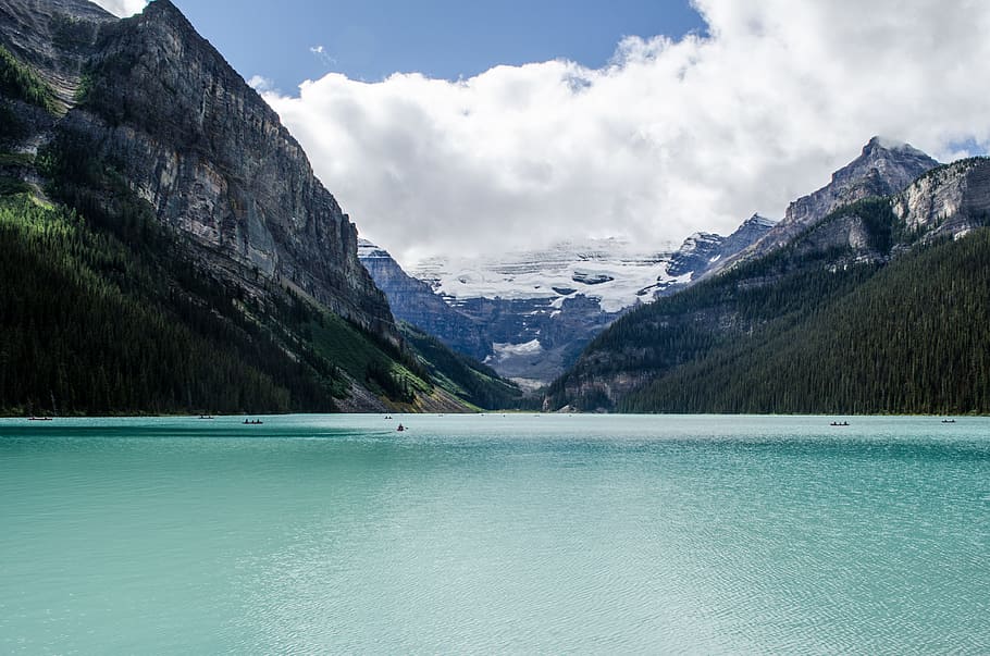 body of water surrounded by mountains, calm body of water in between mountainous terrain under white skies HD wallpaper