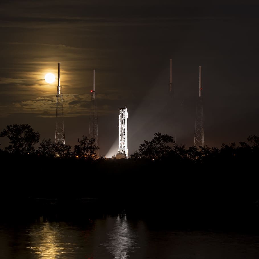 white tower near body of water at nighttime, spacecraft, rocket