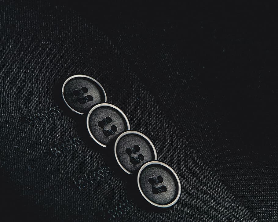 close-up photo of four black shirt buttons, suit, blazer, fashion