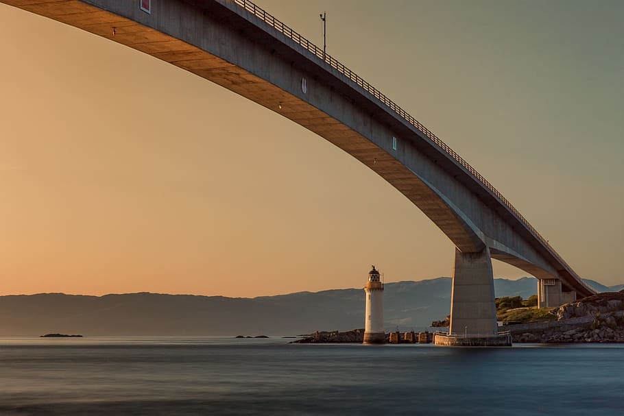 lighthouse under gray bridge during golden hour, sunset, sea HD wallpaper