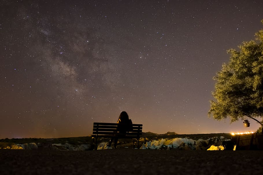 woman sitting on bench along ree, silhouette of a person sitting in the bench watching night sky HD wallpaper