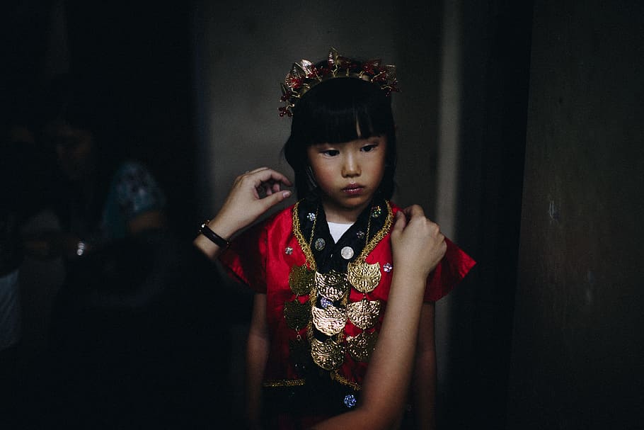 woman fixing girl's dress, girl wearing red and gold traditional clothing HD wallpaper