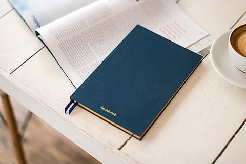 blue hard bind book beside white ceramic coffee cup, blue hardbound book beside cup of coffee late on white wooden table HD wallpaper