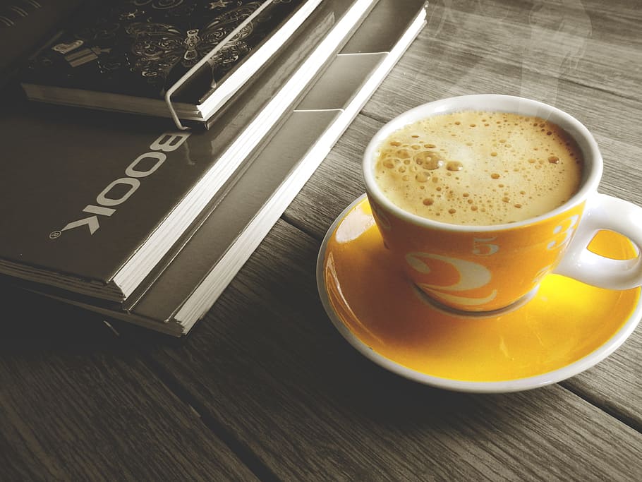 white and yellow ceramic cup filled of coffee beside book, notebook HD wallpaper
