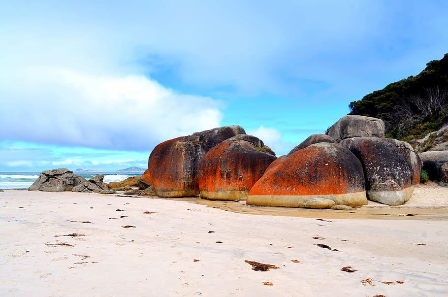 beach during daytime, brown and orange stones on sand, boulder HD wallpaper