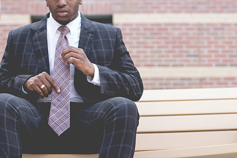 man wearing black-and-gray formal suit sitting on brown wodoen bench HD wallpaper