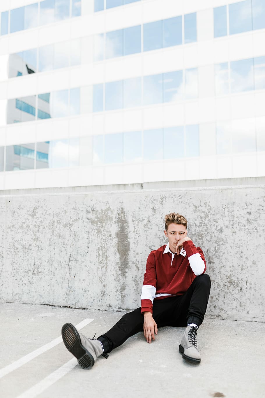 person sitting on white concrete flooring, man leaning on grey concrete pavement HD wallpaper