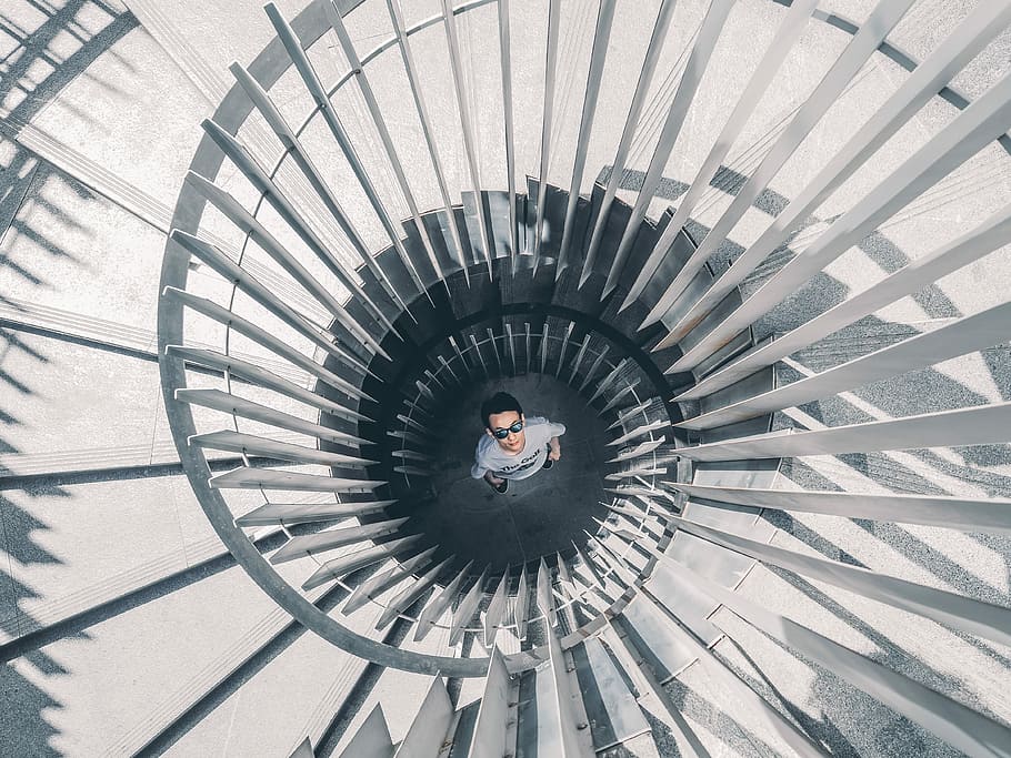 man standing below gray spiral staircases, building, person HD wallpaper