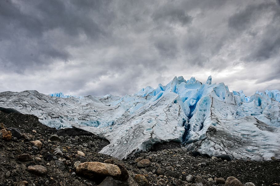 mountain covered with ice under grey cloudy sky, white rock mountain at day time HD wallpaper