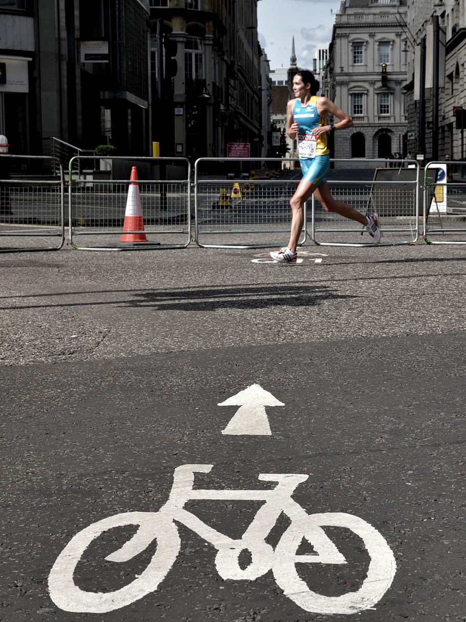 woman running on gray concrete pavement taken at daytime, woman in blue sports top running beside fence HD wallpaper