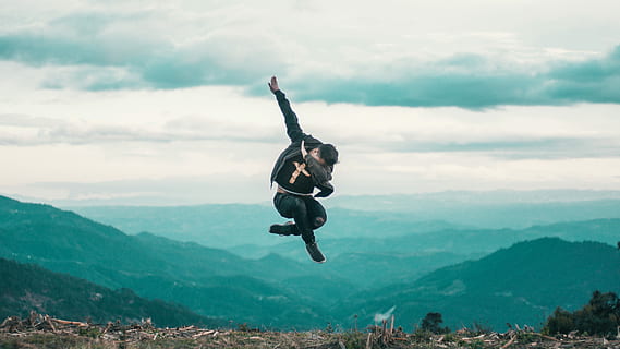 Fly, man wearing black shirt jumping while doing dab during daytime HD wallpaper