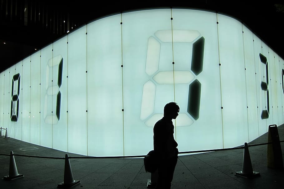 silhouette photo of man standing in front of number display wall HD wallpaper