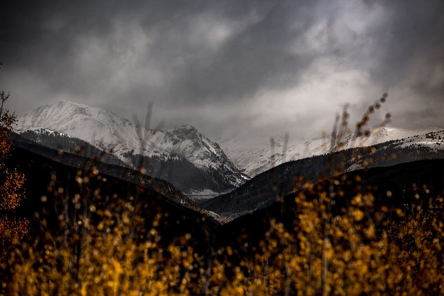 snow mountain covered by dark clouds, mountain ranges at daytime HD wallpaper