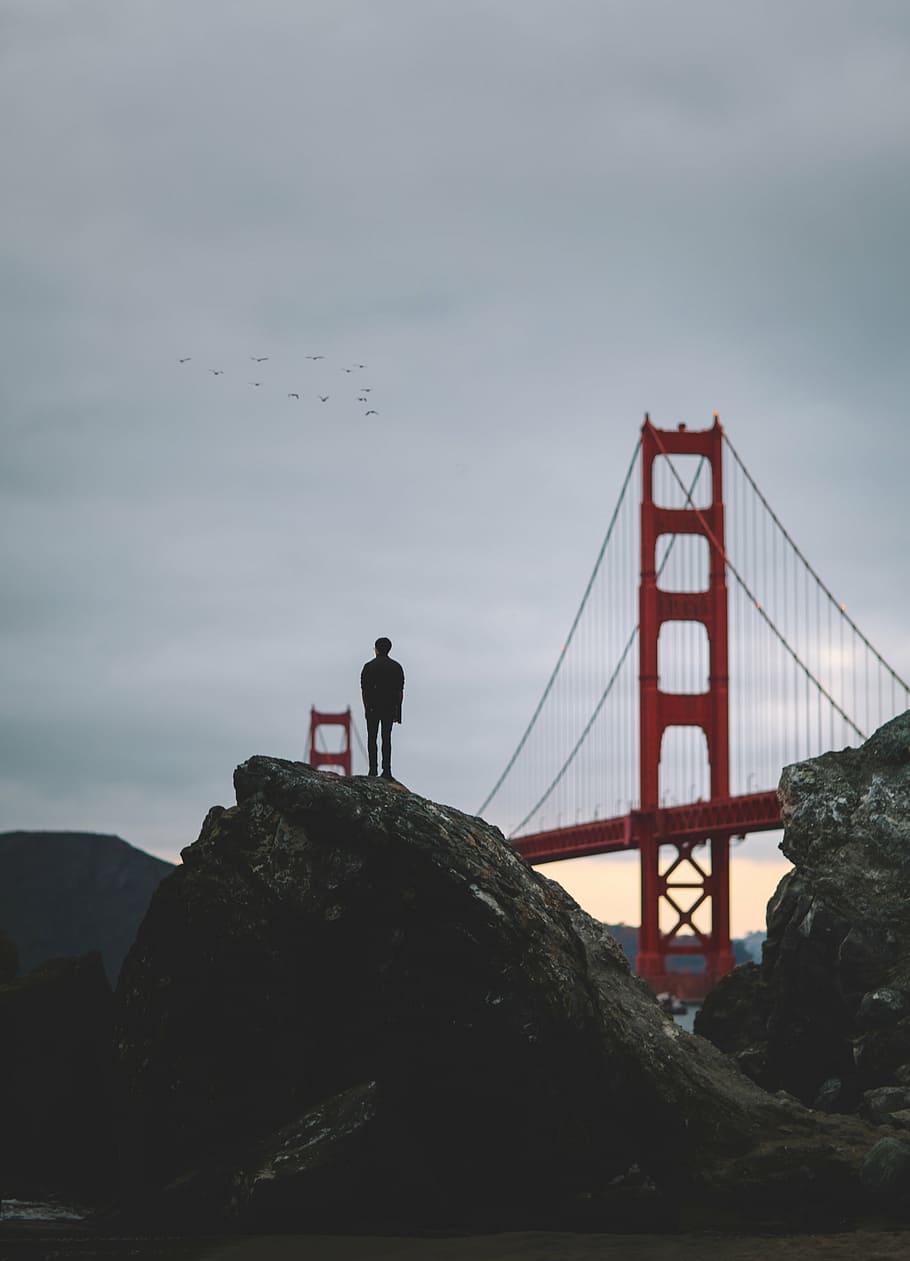 person standing on rock formation near Golden Gate Bridge, stone HD wallpaper