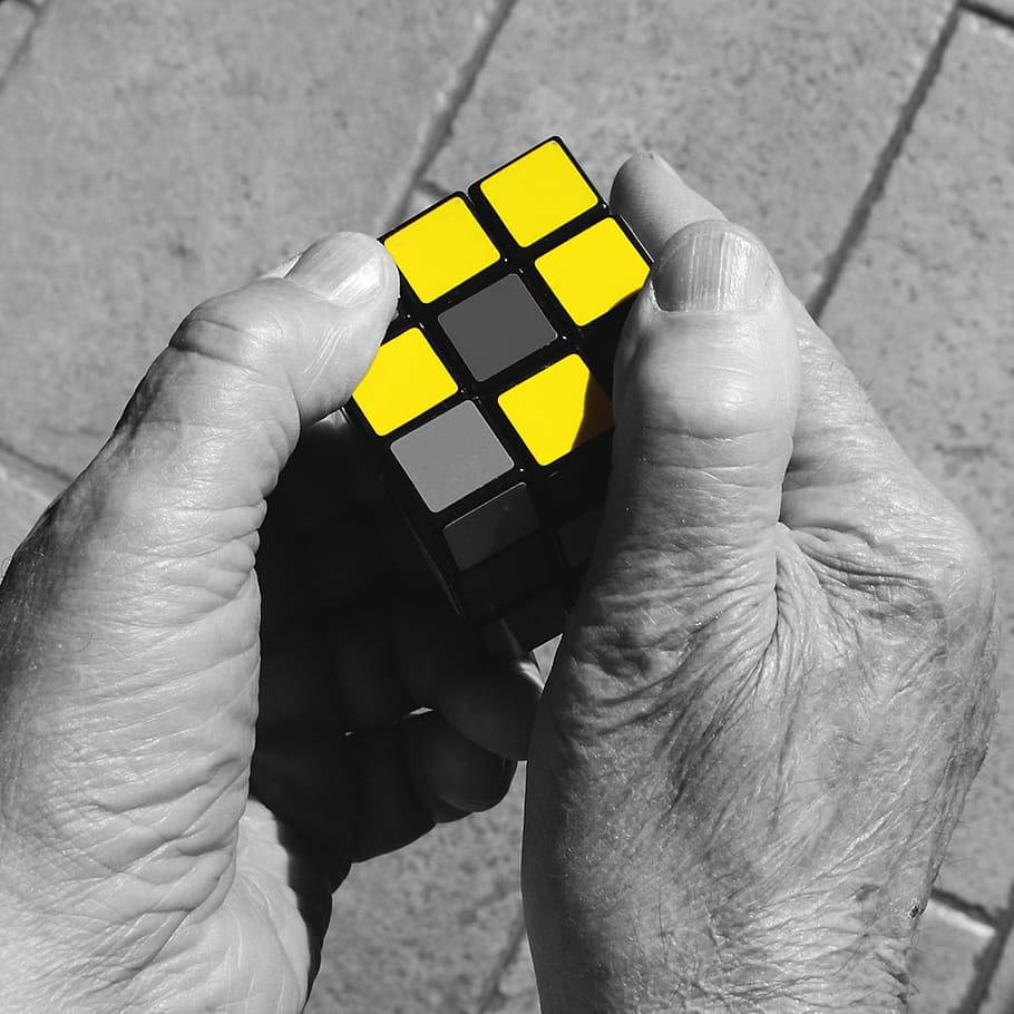 selective color of person holding Rubik's Cube, hands, yellow HD wallpaper
