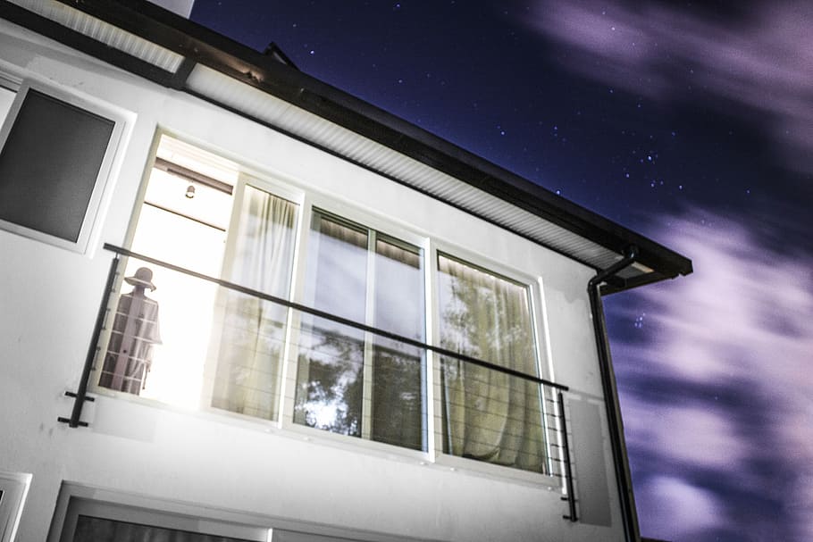 person standing near black terrace, white and black house under starry sky HD wallpaper
