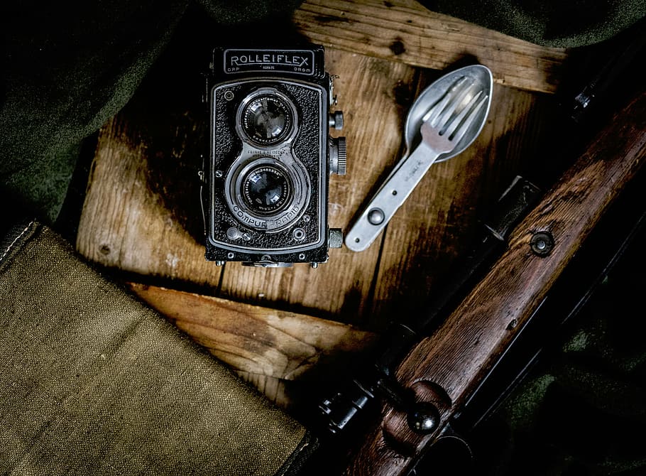 black Rolleflex point-and-shoot camera on brown wood plank HD wallpaper