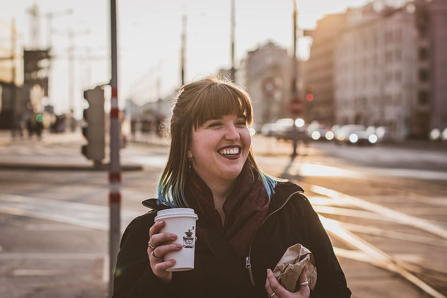 Sunset in Vienna, woman smiling holding disposable cup and paper pack HD wallpaper