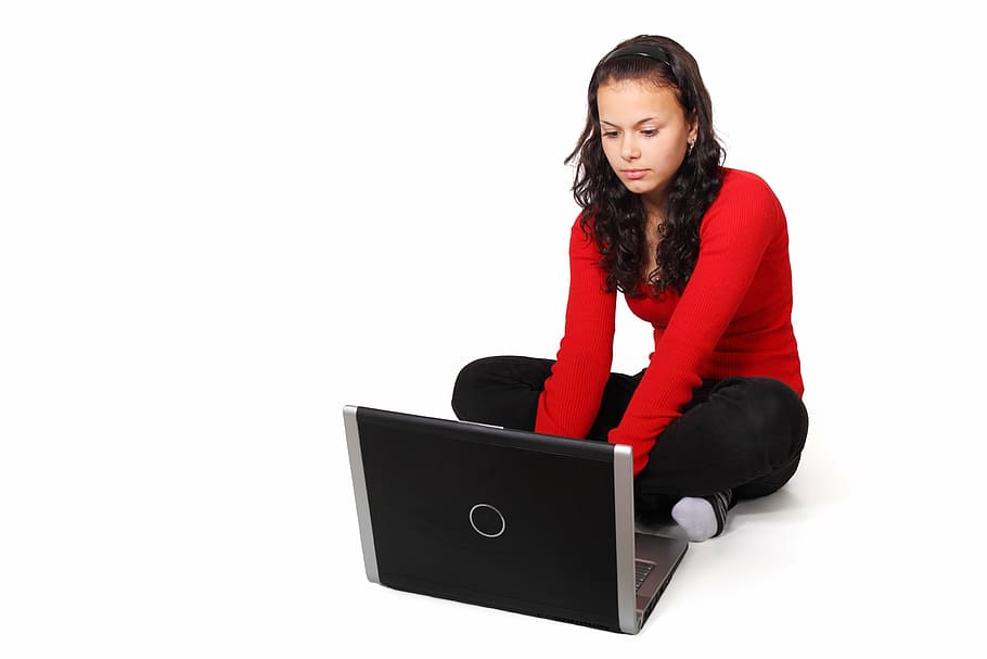 woman wearing red long-sleeve shirt and black pants on squat beside laptop, HD wallpaper
