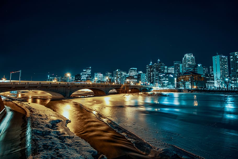 lighted bridge beside buildings, landscaped photo of a high-rise buildings and body of water HD wallpaper