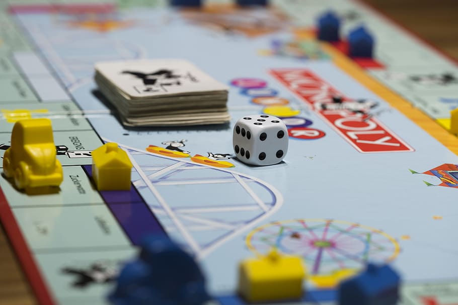 selective focus photography of Monopoly board game with dice and playing card