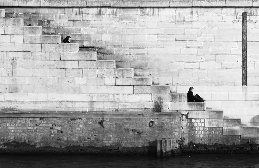 landscape photograph of wall, person sitting on staircase, Gray scale