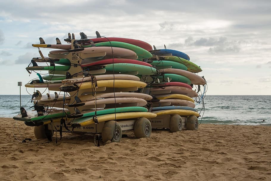 surfing boards on trailer near body of water, surfboards, beach
