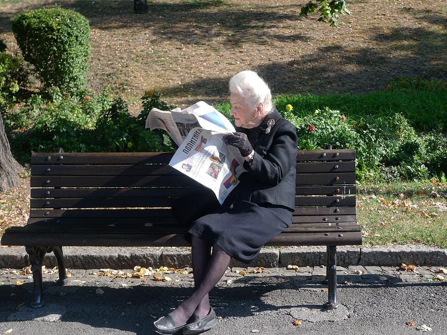 woman sitting on bench reading newspaper at daytime, inform HD wallpaper