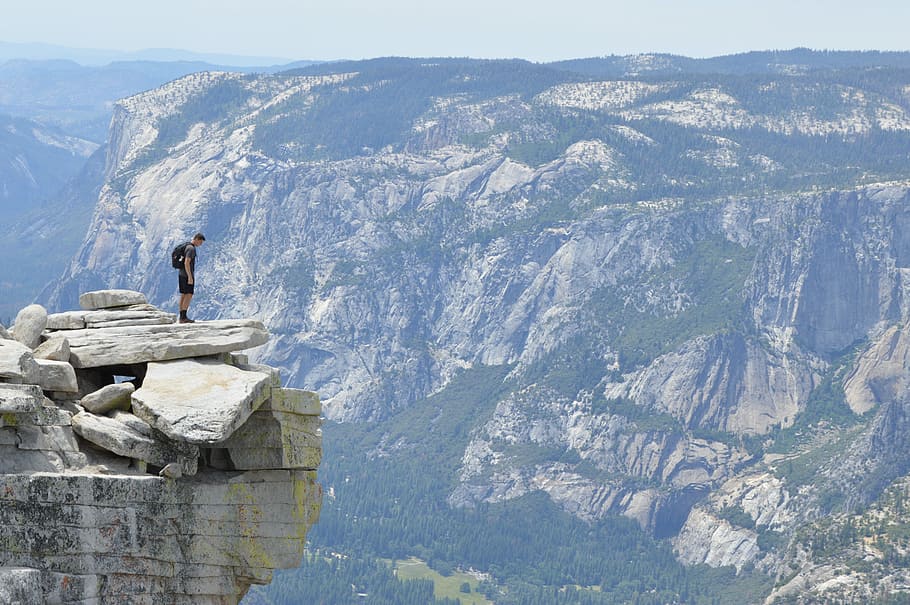 man standing on cliff during daytime, nature, mountain, outdoors HD wallpaper