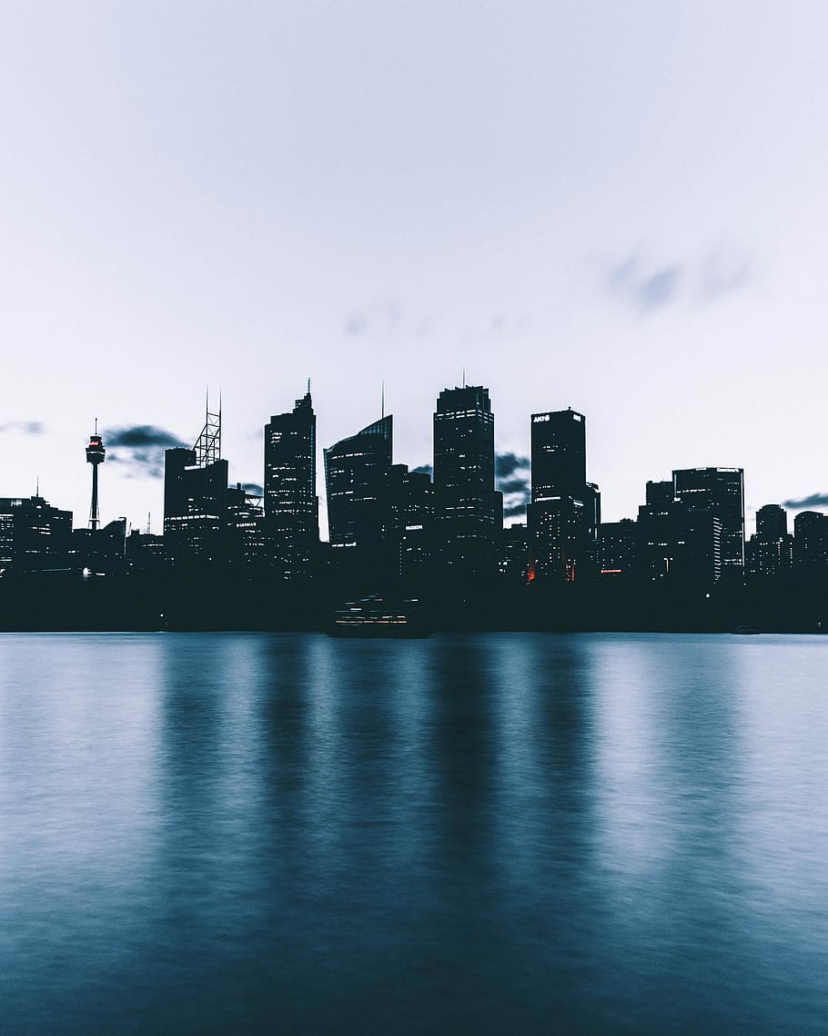 high rise building near on body of water, concrete building near body of water under white clouds HD wallpaper