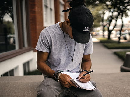 man writing on book near building, people, guy, black, cap HD wallpaper