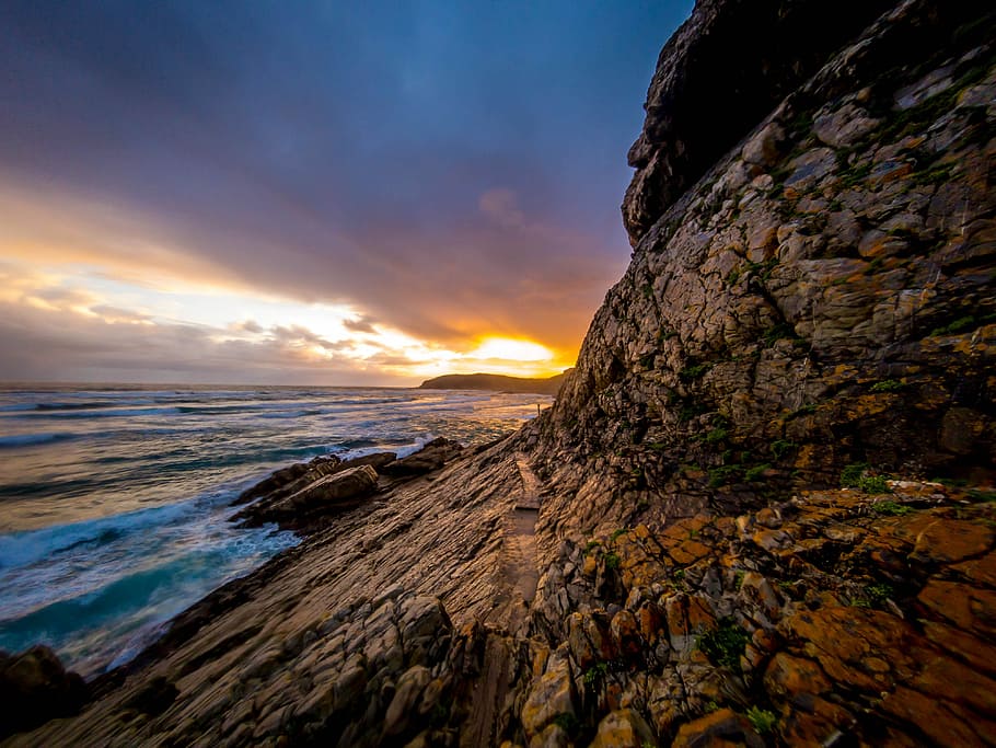brown rock formation near seashore, brown rock cliff near seashore at golden hour HD wallpaper